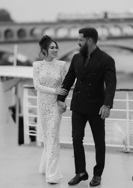 Black and white: a couple on a bridge, the groom in a double-breasted dinner jacket