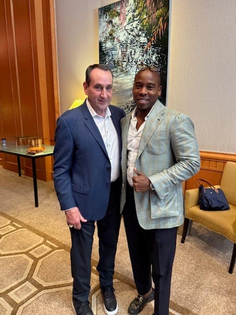 Two clients in tailored jackets at a private event