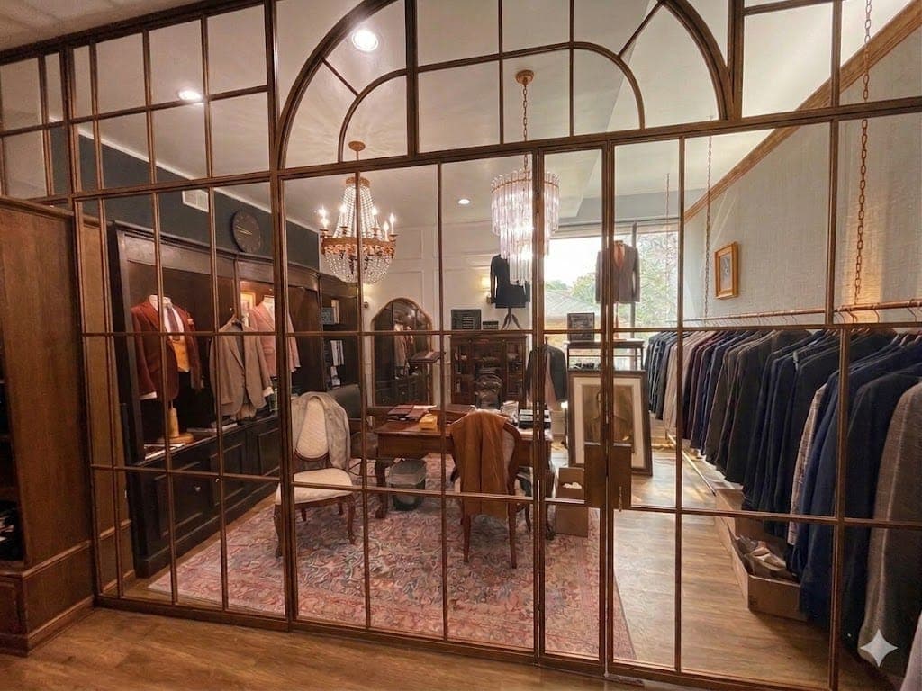The fitting room seen through its arched glass partition, chandeliers above